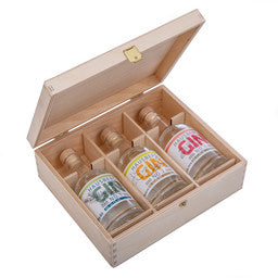 Geöffnete Holzkiste mit Einleger mit drei Gin Tasting-Flaschen. Hausberg Gin Tastingbox. Geschenkset.